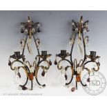 A pair of painted metal twin branch wall sconces, hung with coloured glass drops,