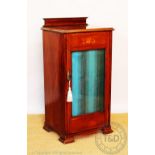 An Edwardian inlaid walnut music cabinet, with hinged top and glazed door, on bracket feet,