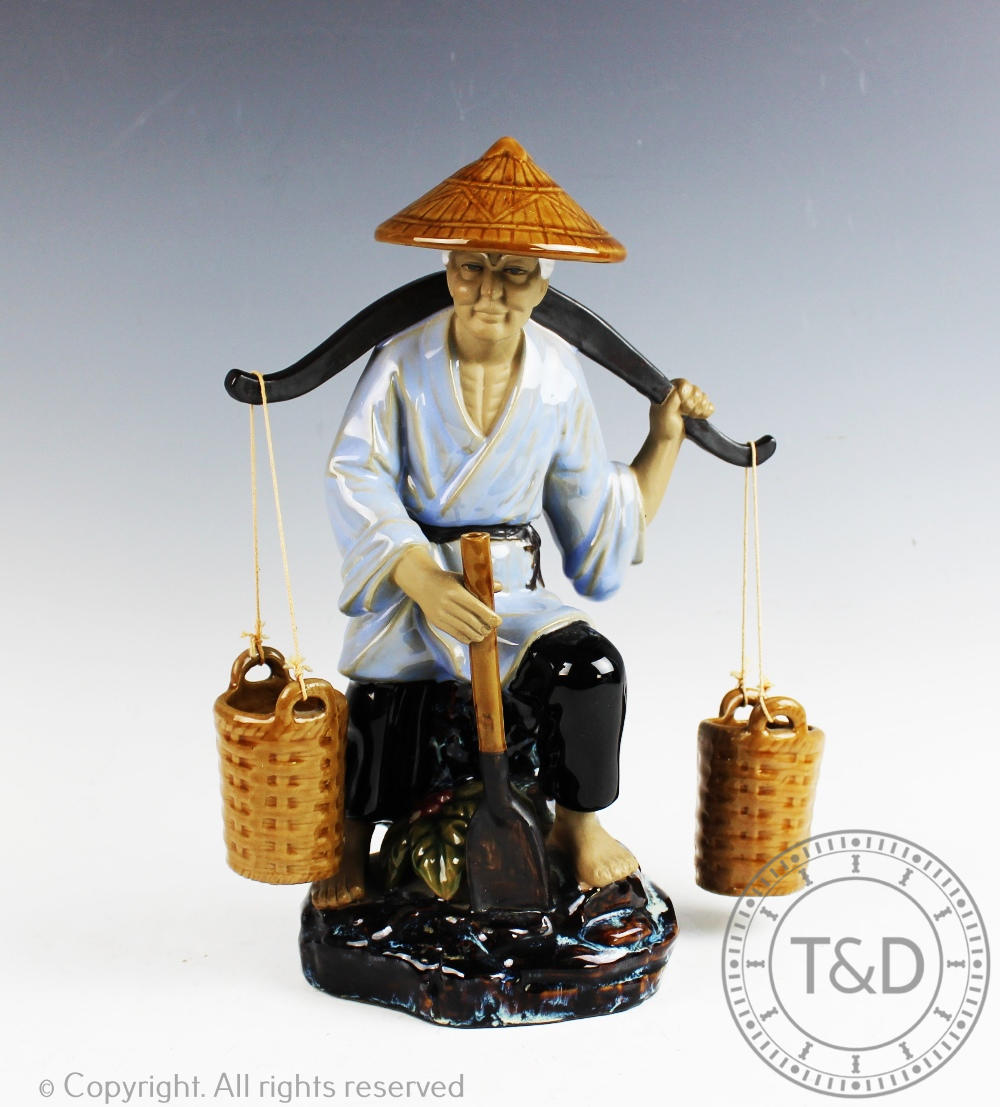 A Chinese Wanjiang pottery model of a field worker, with a shoulder yoke and spade,