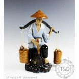 A Chinese Wanjiang pottery model of a field worker, with a shoulder yoke and spade,