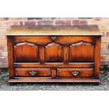 An 18th century style oak mule chest, with panelled front and two drawers, on block feet,