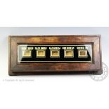 An Edwardian servants bell board, with verre eglomise glazed panel divided for five rooms,