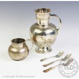 A Victorian silver milk jug, Birmingham 1896, with two American white metal spoons,