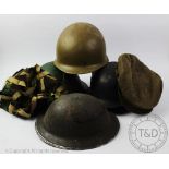 A World War II ARP helmet, with a German helmet,