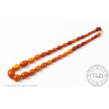 A 'butterscotch' amber bead necklace, the single strand,