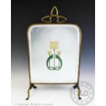 An Art Nouveau brass fire screen set with bevelled glass,