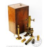 A late Victorian lacquered brass microscope, within a fitted mahogany case, with associated slides,