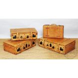 A set of four tan leather suit cases,