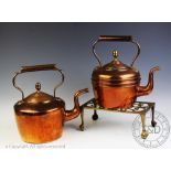Two early 20th century copper kettles, tallest 28cm high, with a brass footman,