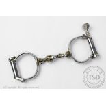 A pair of early 20th century stainless steel police officers handcuffs with key