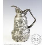 An Art Nouveau pewter ewer, of shaped form and cast with flowers,