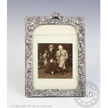 An Edwardian silver photograph frame, of rectangular shape embossed with floral scrolls,