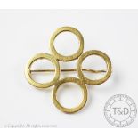 A yellow metal brooch, designed as four circles, stamped verso indistinctly '14ct', gross weight 13.