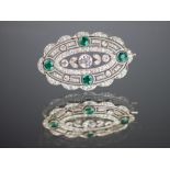 A diamond and emerald set brooch, early 20th century, the oval brooch of openwork form,