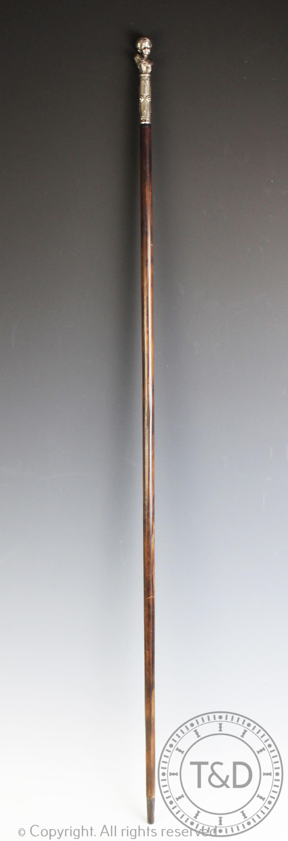 An early 20th century French walking cane, with white metal mount of an infant,
