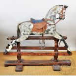 An early 20th century wood and gesso rocking horse, with dappled grey detailing, on pine stand,