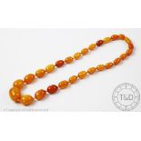 A 'butterscotch' amber bead necklace, the single strand of graduated beads, with bead screw clasp,