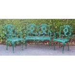 A green painted metal three piece garden bench and chairs,