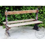 A cast aluminium and wood double sided station type bench, decorated with scrolls and shields,