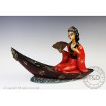 An early 20th century novelty plaster lamp, modelled as a Geisha in a boat, 44cm long,