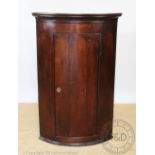 A George III oak bow front corner cabinet, 105cm H x 67cm W Provenance: Clynog Farmhouse,