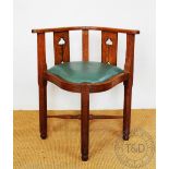 An Arts and Crafts style oak corner or desk chair, the splats with pierced flower detailing,