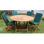 A teak garden table and four folding chairs,
