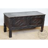 A 17th century Welsh oak coffer with later carved detailing, on stile legs,