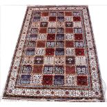 A Kashmir garden panel design carpet, worked with sixty floral panels against an ivory ground,