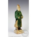 A Chinese funerary figure, Tang Dynasty, earthenware body, glazed in green,