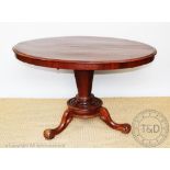 A Victorian walnut oval loo table, on turned column and platform, with scroll legs,