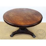 A William IV circular breakfast table, with turned tapering column and platform on carved paw feet,