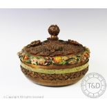 A Victorian papier mache and carved wood circular box and cover,