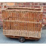 A vintage French wicker laundry basket, on two wheels,