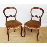 A pair of Victorian carved walnut side chairs on cabriole legs, upholstered seats,