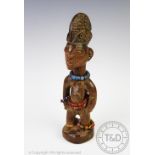 A West African Nigerian carved wood Ibeji doll figure, with bead detailing,