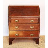 An Edwardian inlaid oak bureau, three long drawers with Art Nouveau brass handles, on bracket feet,