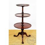 A George III style mahogany three tier dumb waiter, on claw and ball feet,