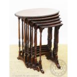 A 1920's figured walnut oval nest of five tables, on tuned legs and scroll feet,