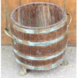 An early 20th century coopered log bin on brass paw feet, 42cm high Provenance: Clynog Farmhouse,