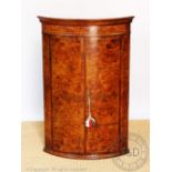 A George III style inlaid walnut bow front corner cabinet,