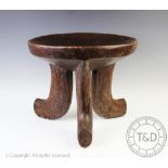 An East African Ethiopian tribal art carved wood stool, with dished circular seat,