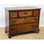 A George III oak chest, of three short and two long drawers, on bracket feet,