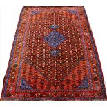 A Persian wool carpet, with overall geometric design and central blue medallion,