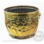 A Dutch embossed brass log bin with heraldic detailing and lions mask handles,