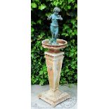 A Victorian style garden cast iron figure on column stand, of a putto holding a butterfly, at fault,