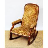 A Victorian walnut rocking chair with upholstered back, seat and arms,