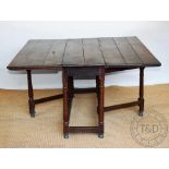 An early 18th century oak gateleg table with square flaps on turned and block feet,