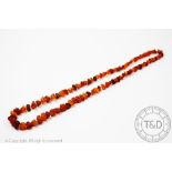 An amber coloured bead necklace, the single strand necklace on knotted string,