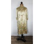 A Chinese silk day robe, worked with flowers against a golden coloured ground,
